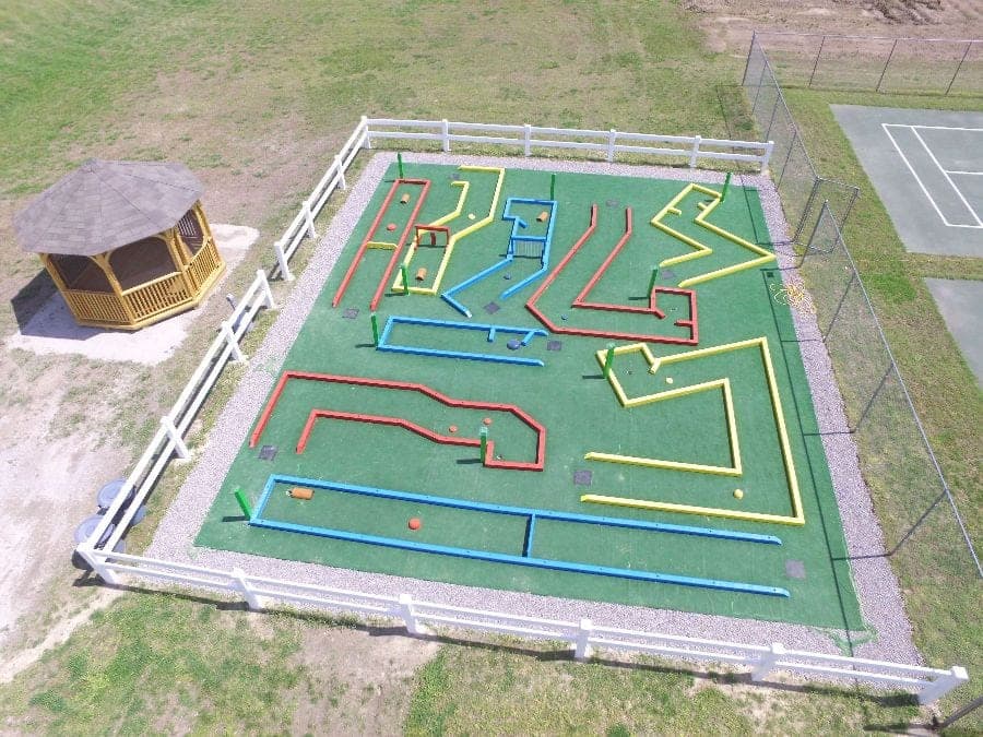 Colorful mini golf course with gazebo and tennis court nearby
