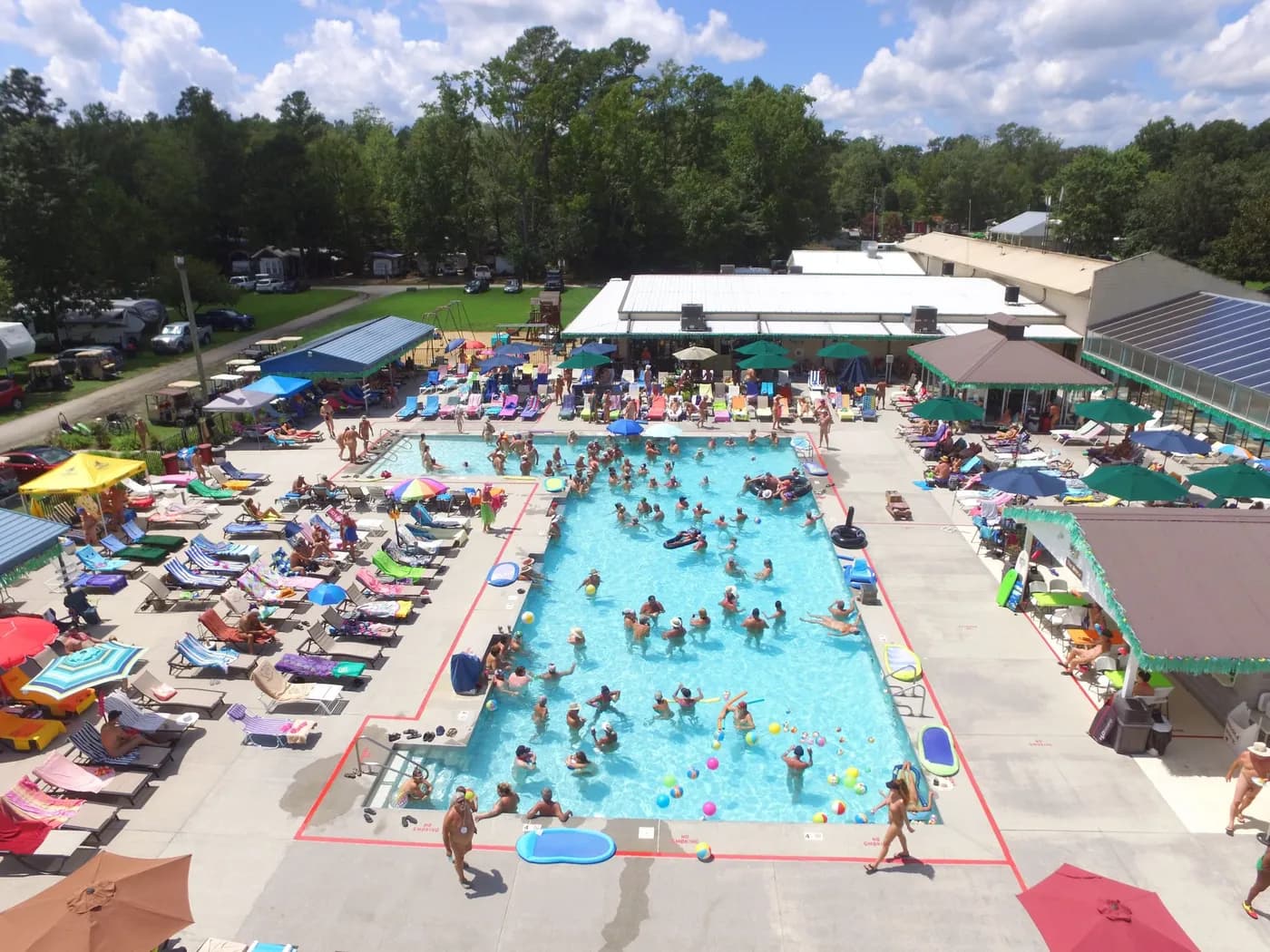 Aerial view of White Tail Resort pool and surrounding grounds on a busy summer day