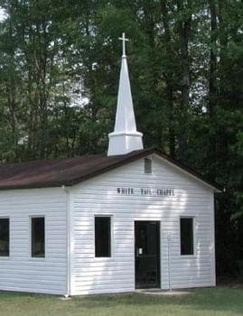 White Tail Chapel, a quaint white church with steeple nestled among trees